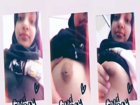 A beautiful girl in a hijab flaunts her large breasts in front of the camera
