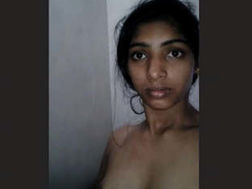 A seductive woman flaunting her breasts and buttocks in a bathroom